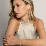 Model wearing long dangling freshwater pearl and solid gold earring