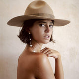 Model wearing long dangling freshwater pearl and solid gold earring