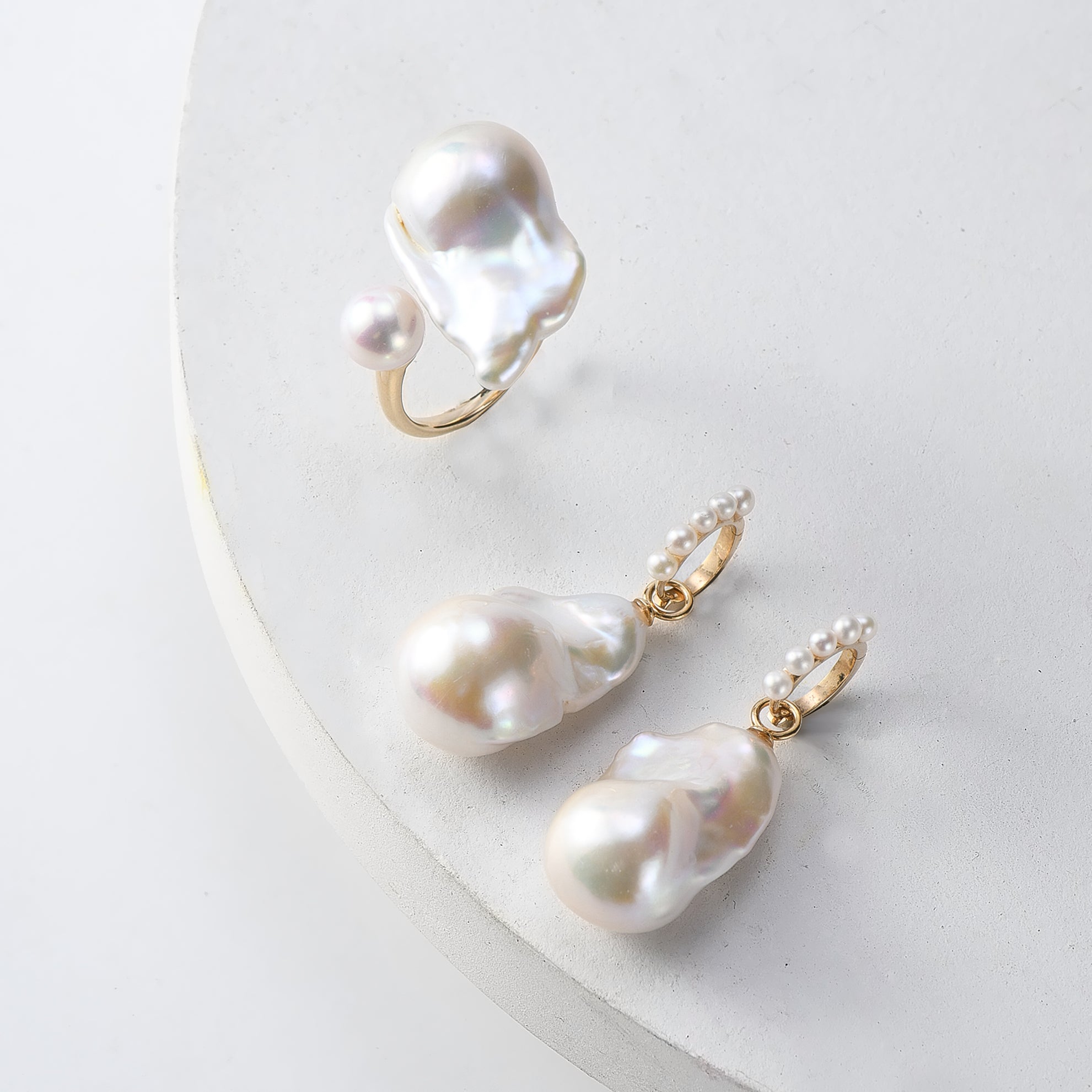 Flat lay image of baroque pearl ring and baroque pearl earrings