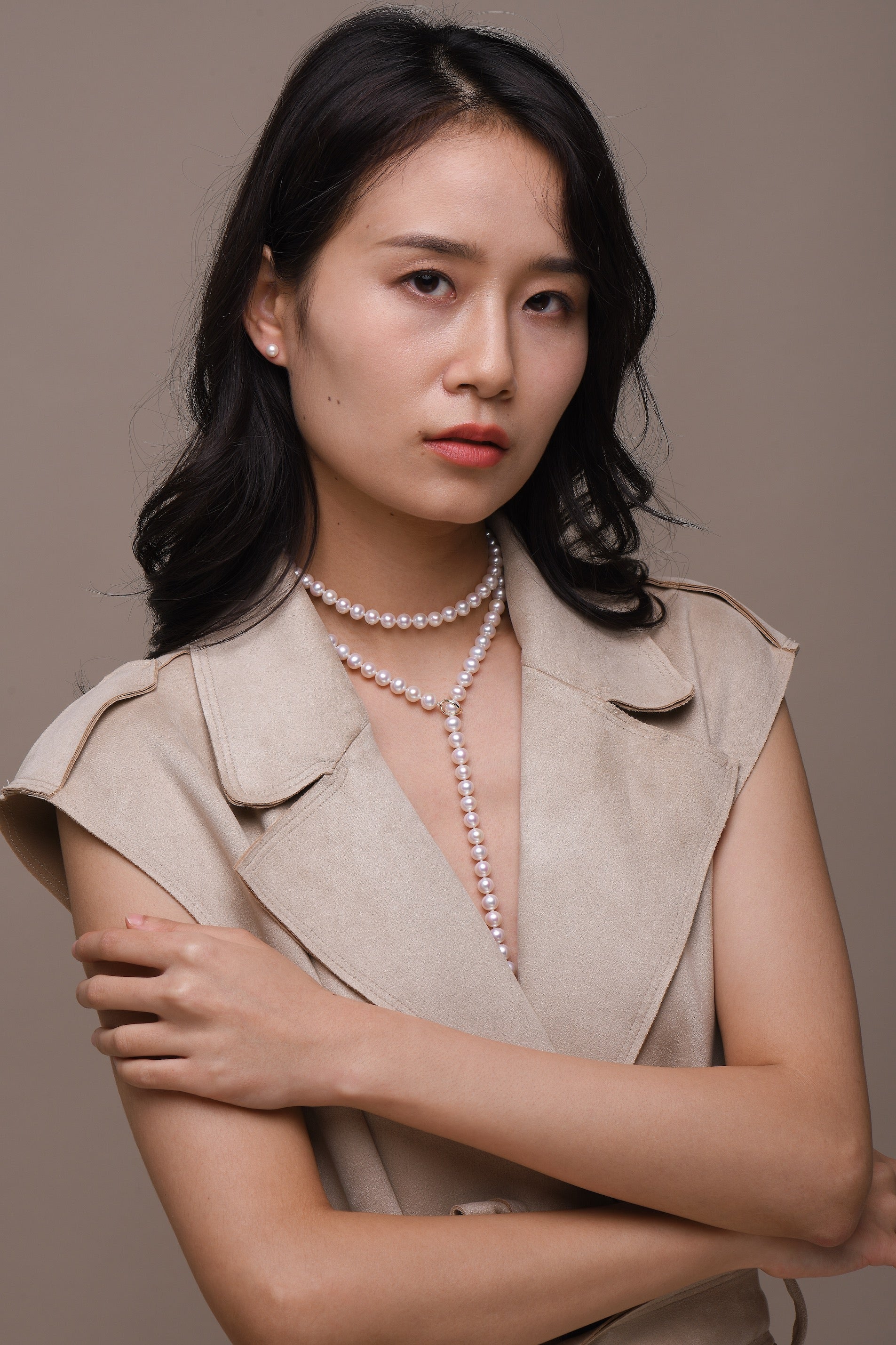 Model wearing pearl earrings and necklace